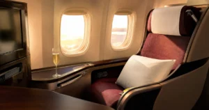 Business Class fliegen mit Meilen – Berry-roter Sitz mit Champagner und Fensterblick